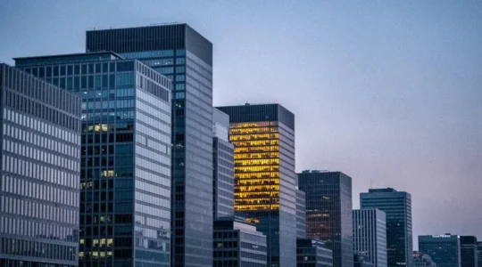 A single distinctively lit building glowing among a dense row of uniform grey office towers, symbolizing SaaS differentiation in a saturated market