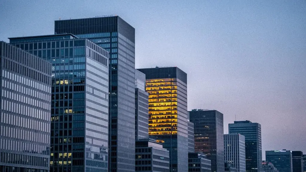 A single distinctively lit building glowing among a dense row of uniform grey office towers, symbolizing SaaS differentiation in a saturated market